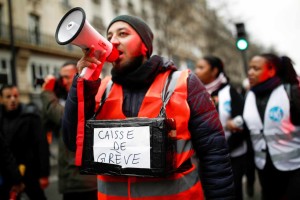 FILE PHOTO: A protestor holds a box for strike fund donations during a demonstration after 24 days of strike against French government's pensions reform plans in Paris, France, December 28, 2019. REUTERS/Benoit Tessier/File Photo